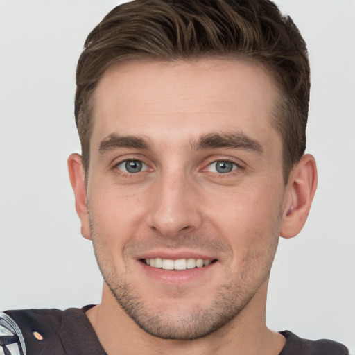 Joyful white young-adult male with short  brown hair and grey eyes