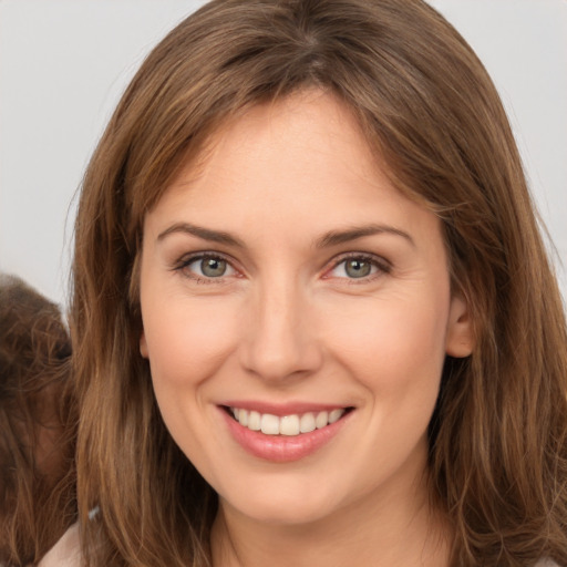 Joyful white young-adult female with long  brown hair and brown eyes