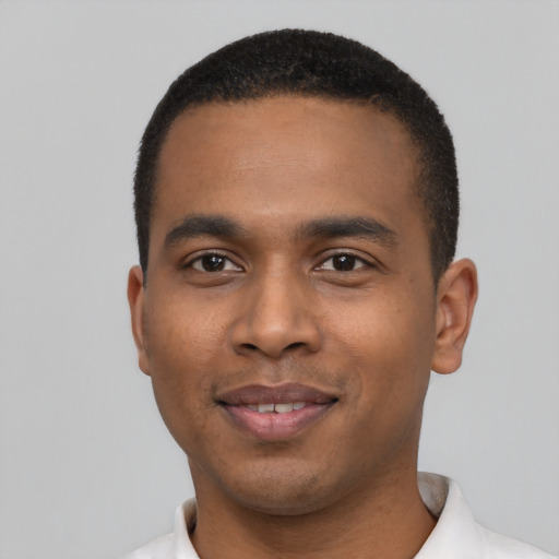 Joyful black young-adult male with short  black hair and brown eyes