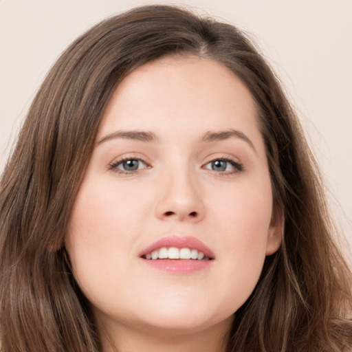 Joyful white young-adult female with long  brown hair and grey eyes