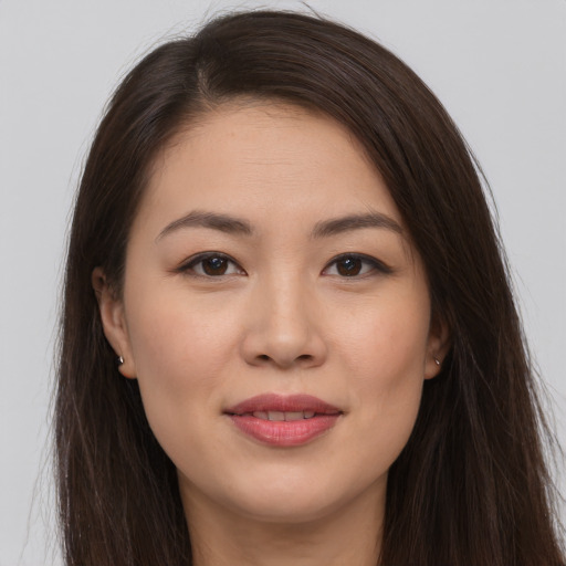 Joyful white young-adult female with long  brown hair and brown eyes