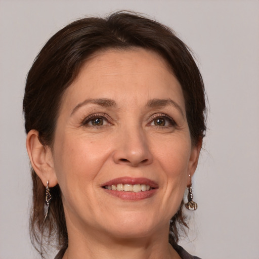 Joyful white adult female with medium  brown hair and grey eyes