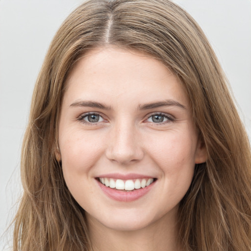 Joyful white young-adult female with long  brown hair and grey eyes