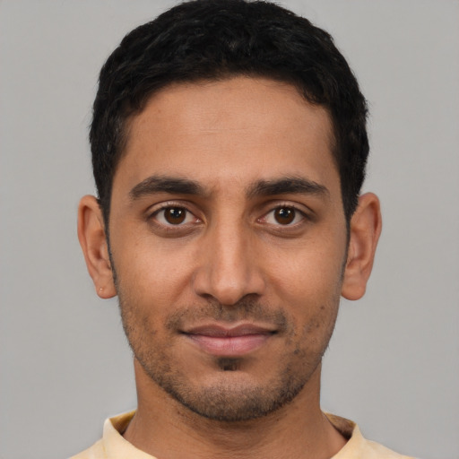 Joyful latino young-adult male with short  black hair and brown eyes