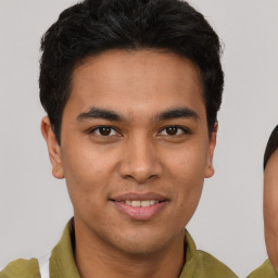 Joyful latino young-adult male with short  brown hair and brown eyes