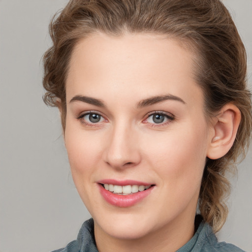 Joyful white young-adult female with medium  brown hair and grey eyes