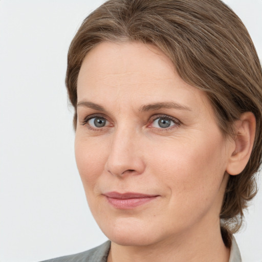 Joyful white adult female with medium  brown hair and grey eyes