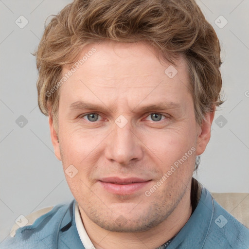 Joyful white adult male with short  brown hair and blue eyes