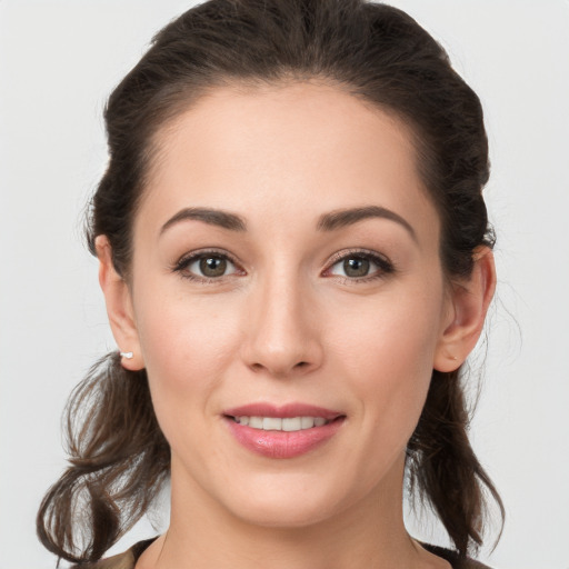 Joyful white young-adult female with medium  brown hair and grey eyes