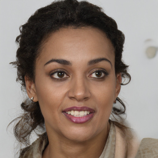 Joyful black young-adult female with long  brown hair and brown eyes