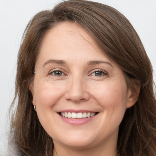 Joyful white young-adult female with long  brown hair and grey eyes