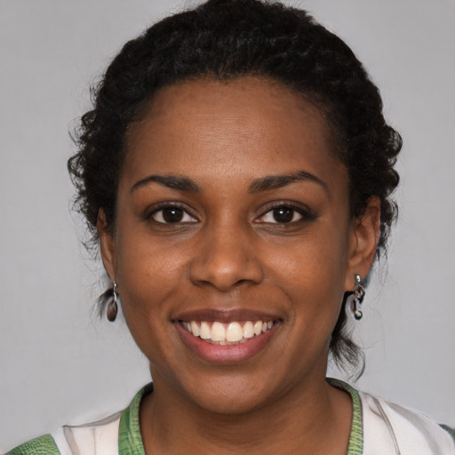 Joyful black young-adult female with short  black hair and brown eyes