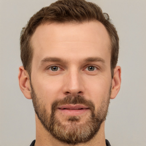 Joyful white young-adult male with short  brown hair and grey eyes