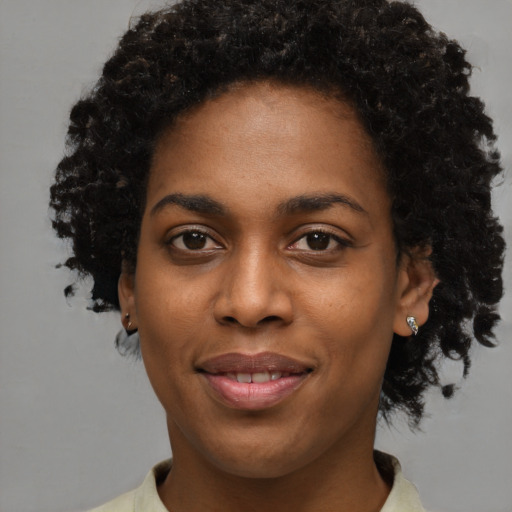 Joyful black young-adult female with short  brown hair and brown eyes