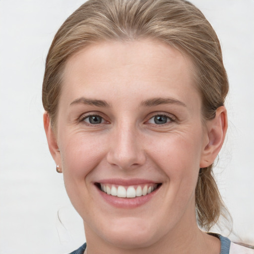 Joyful white young-adult female with medium  brown hair and blue eyes