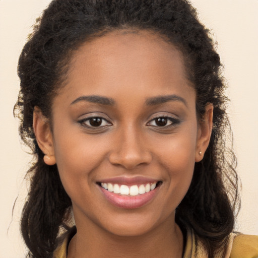 Joyful black young-adult female with long  brown hair and brown eyes