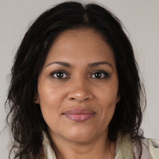 Joyful black young-adult female with long  brown hair and brown eyes