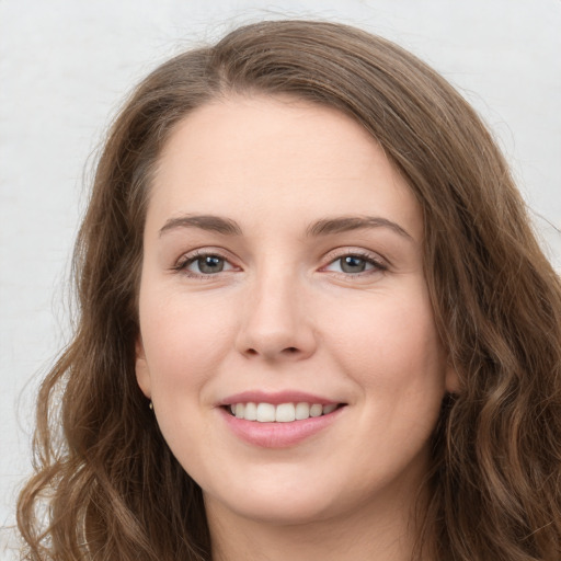 Joyful white young-adult female with long  brown hair and green eyes