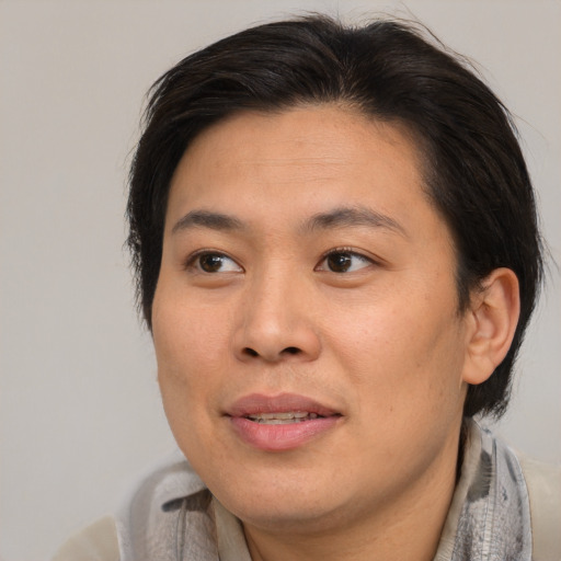 Joyful asian adult female with short  brown hair and brown eyes