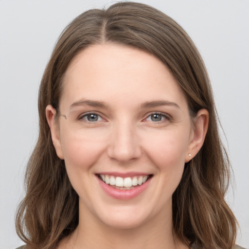 Joyful white young-adult female with long  brown hair and grey eyes