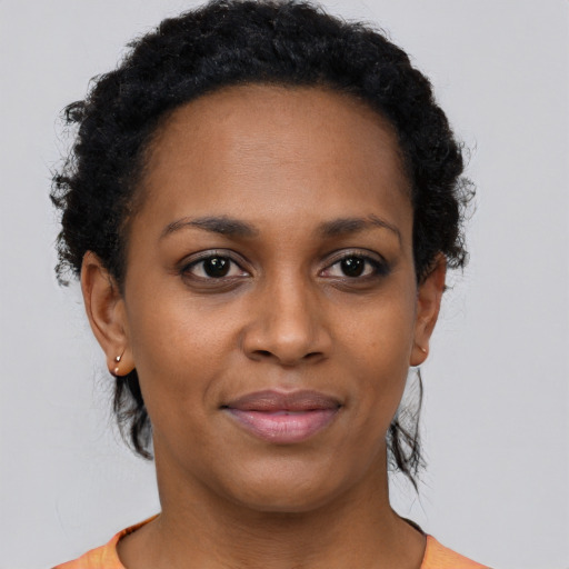 Joyful black young-adult female with short  brown hair and brown eyes