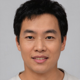 Joyful asian young-adult male with short  black hair and brown eyes