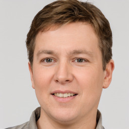 Joyful white young-adult male with short  brown hair and grey eyes