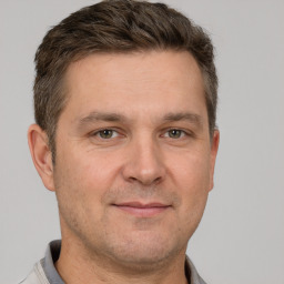 Joyful white adult male with short  brown hair and grey eyes