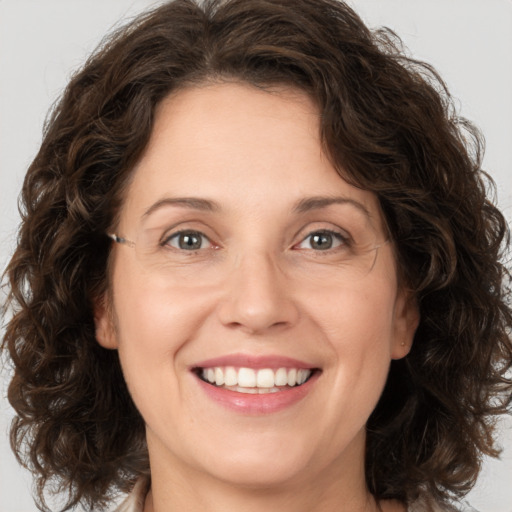 Joyful white young-adult female with medium  brown hair and green eyes