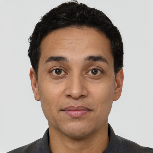 Joyful white adult male with short  black hair and brown eyes