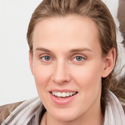 Joyful white young-adult female with long  brown hair and blue eyes