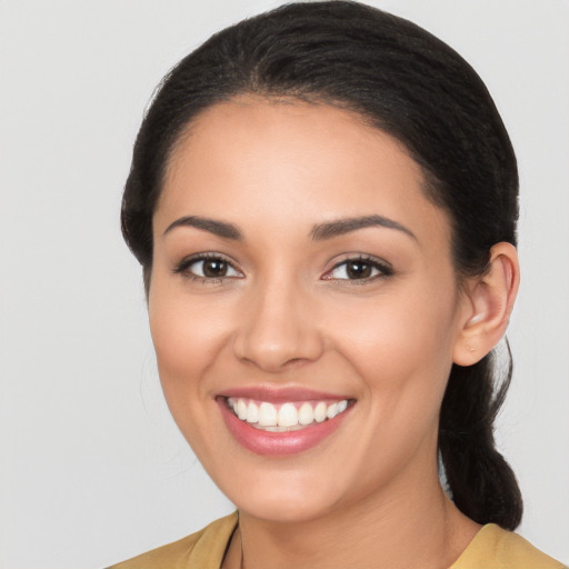 Joyful latino young-adult female with long  brown hair and brown eyes