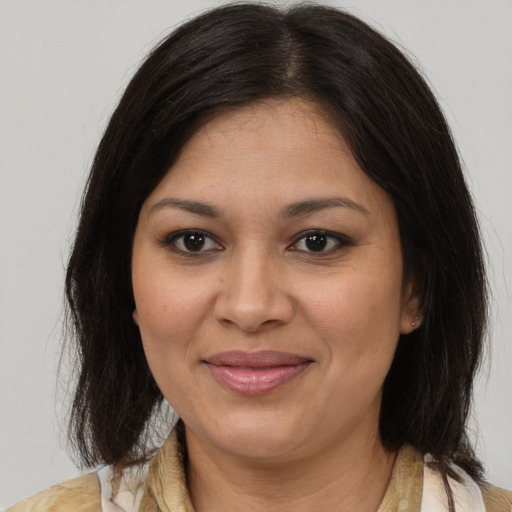 Joyful latino adult female with medium  brown hair and brown eyes