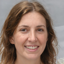 Joyful white adult female with medium  brown hair and grey eyes