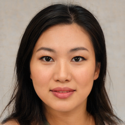Joyful asian young-adult female with long  brown hair and brown eyes