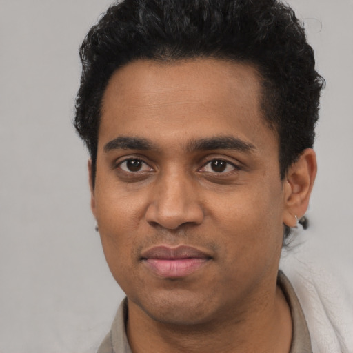 Joyful black young-adult male with short  black hair and brown eyes