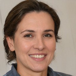 Joyful white adult female with medium  brown hair and brown eyes