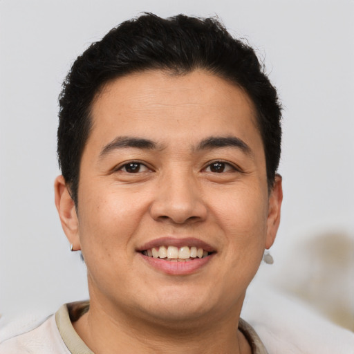 Joyful latino young-adult male with short  brown hair and brown eyes