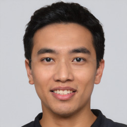 Joyful asian young-adult male with short  black hair and brown eyes