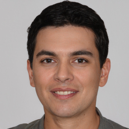 Joyful white young-adult male with short  black hair and brown eyes