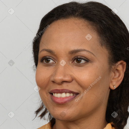 Joyful black adult female with long  brown hair and brown eyes