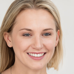 Joyful white young-adult female with long  brown hair and blue eyes