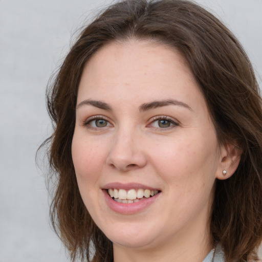 Joyful white young-adult female with long  brown hair and grey eyes