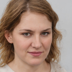 Joyful white young-adult female with medium  brown hair and green eyes