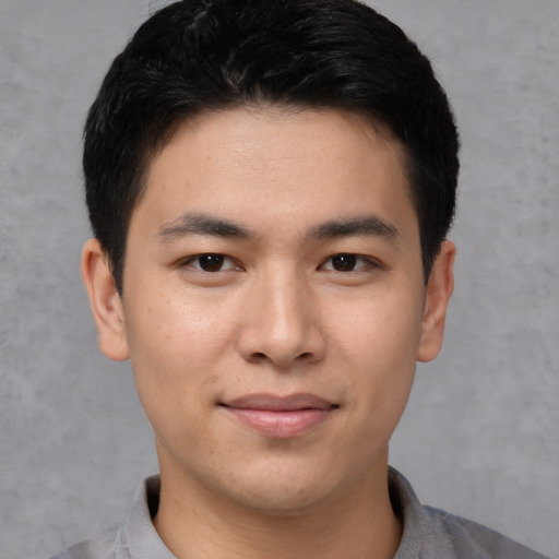 Joyful asian young-adult male with short  black hair and brown eyes