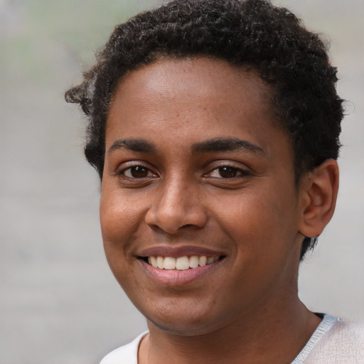 Joyful black young-adult female with short  brown hair and brown eyes