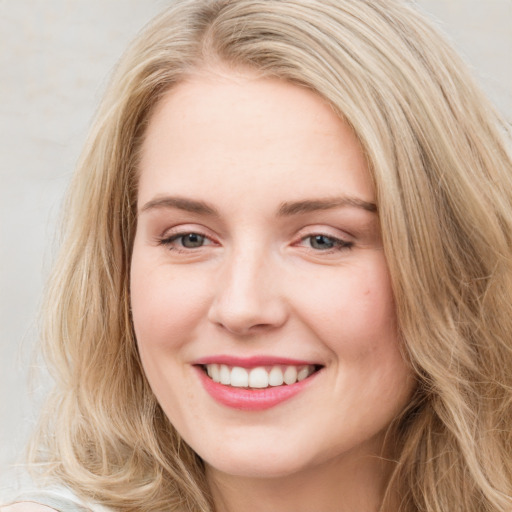 Joyful white young-adult female with long  brown hair and blue eyes