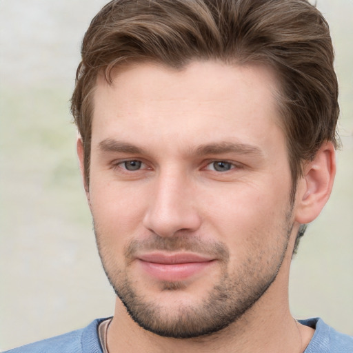 Joyful white young-adult male with short  brown hair and grey eyes