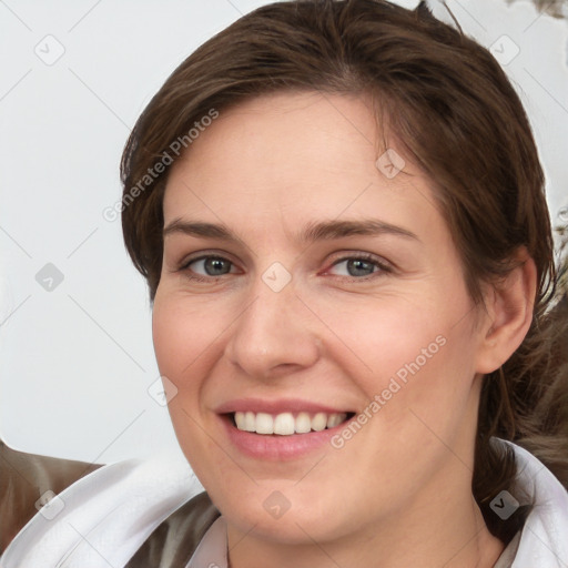 Joyful white young-adult female with medium  brown hair and grey eyes