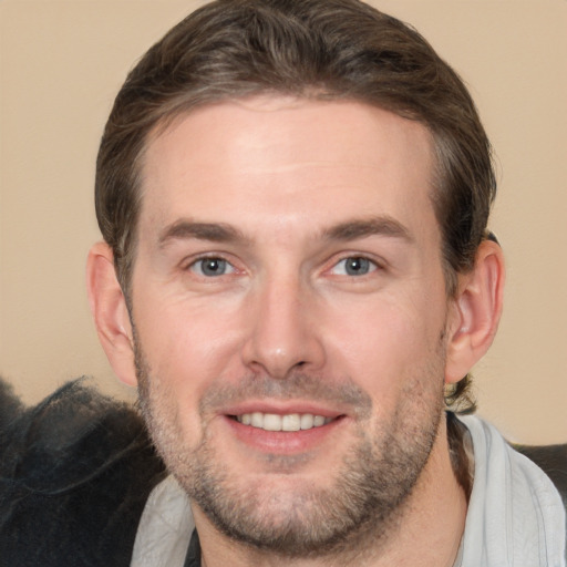 Joyful white adult male with short  brown hair and brown eyes